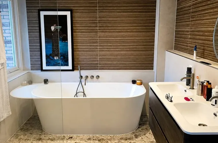 Maatwerk sanitair en tegelwerk in een gerenoveerde badkamer.