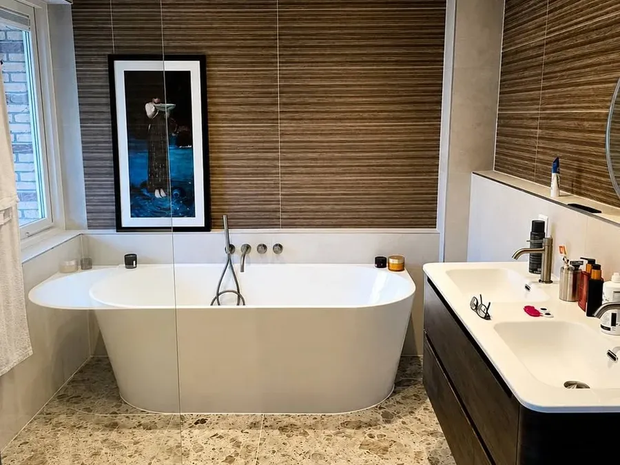 Maatwerk sanitair en tegelwerk in een gerenoveerde badkamer.