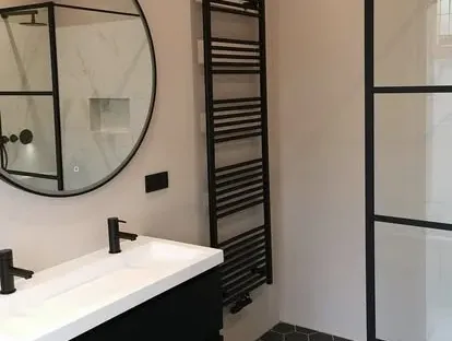 Maatwerk sanitair en tegelwerk in een gerenoveerde badkamer.