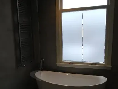 Maatwerk sanitair en tegelwerk in een gerenoveerde badkamer.