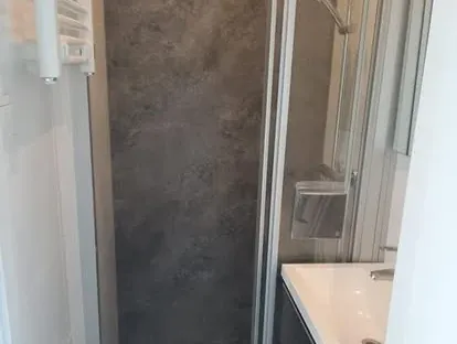 Badkamerrenovatie met zorgvuldig afgestemd sanitair, tegelwerk en verlichting.