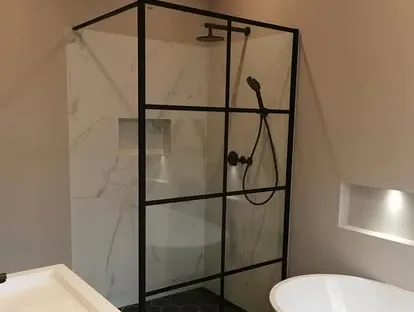 Maatwerk sanitair en tegelwerk in een gerenoveerde badkamer.