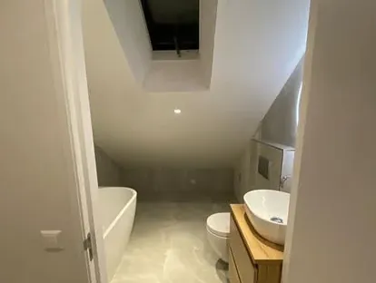 Maatwerk sanitair en tegelwerk in een gerenoveerde badkamer.