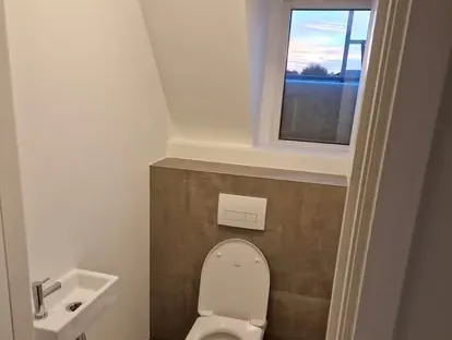 Badkamerrenovatie met zorgvuldig afgestemd sanitair, tegelwerk en verlichting.