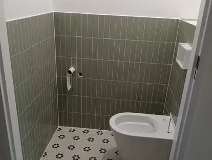 Maatwerk sanitair en tegelwerk in een gerenoveerde badkamer.