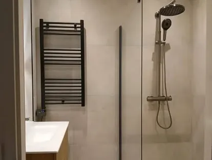 Maatwerk sanitair en tegelwerk in een gerenoveerde badkamer.