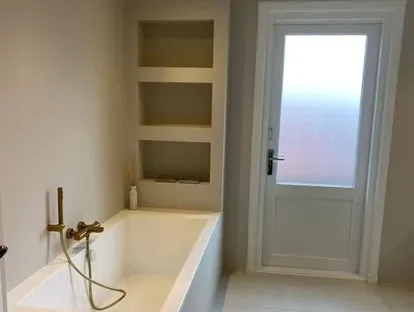 Badkamerrenovatie met zorgvuldig afgestemd sanitair, tegelwerk en verlichting.