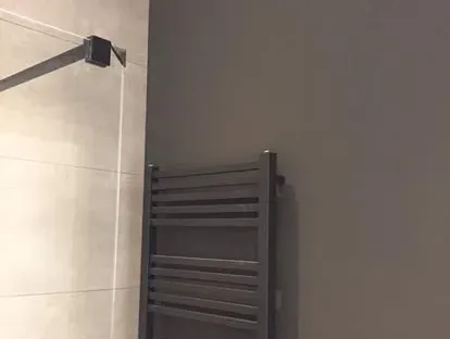 Badkamerrenovatie met zorgvuldig afgestemd sanitair, tegelwerk en verlichting.