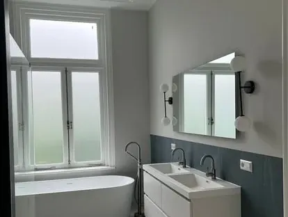 Maatwerk sanitair en tegelwerk in een gerenoveerde badkamer.