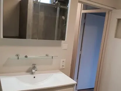 Badkamerrenovatie met zorgvuldig afgestemd sanitair, tegelwerk en verlichting.