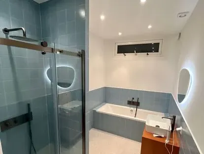 Maatwerk sanitair en tegelwerk in een gerenoveerde badkamer.