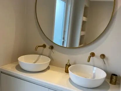 Badkamerrenovatie met zorgvuldig afgestemd sanitair, tegelwerk en verlichting.
