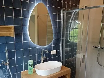 Maatwerk sanitair en tegelwerk in een gerenoveerde badkamer.