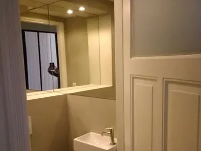 Badkamerrenovatie met zorgvuldig afgestemd sanitair, tegelwerk en verlichting.