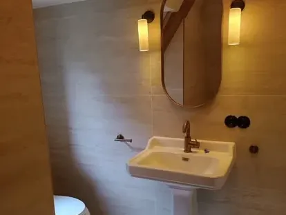 Badkamerrenovatie met zorgvuldig afgestemd sanitair, tegelwerk en verlichting.