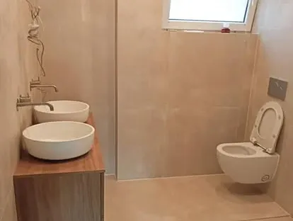 Badkamerrenovatie met zorgvuldig afgestemd sanitair, tegelwerk en verlichting.
