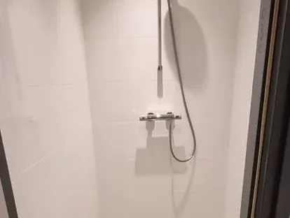 Badkamerrenovatie met zorgvuldig afgestemd sanitair, tegelwerk en verlichting.
