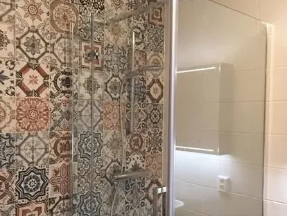 Maatwerk sanitair en tegelwerk in een gerenoveerde badkamer.