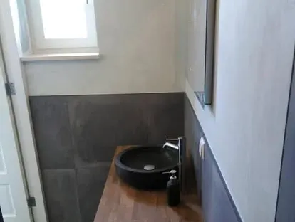 Badkamerrenovatie met zorgvuldig afgestemd sanitair, tegelwerk en verlichting.