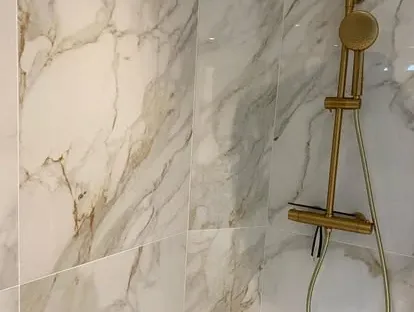 Maatwerk sanitair en tegelwerk in een gerenoveerde badkamer.