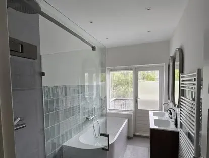 Maatwerk sanitair en tegelwerk in een gerenoveerde badkamer.