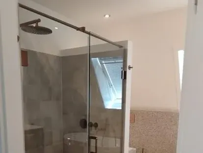 Badkamerrenovatie met zorgvuldig afgestemd sanitair, tegelwerk en verlichting.