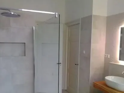 Maatwerk sanitair en tegelwerk in een gerenoveerde badkamer.