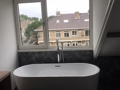 Maatwerk sanitair en tegelwerk in een gerenoveerde badkamer.