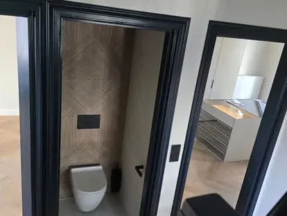 Badkamerrenovatie met zorgvuldig afgestemd sanitair, tegelwerk en verlichting.