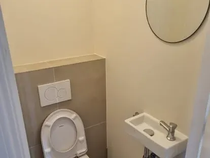 Maatwerk sanitair en tegelwerk in een gerenoveerde badkamer.