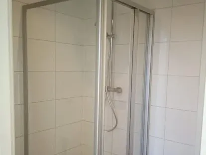 Badkamerrenovatie met zorgvuldig afgestemd sanitair, tegelwerk en verlichting.