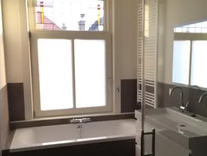 Maatwerk sanitair en tegelwerk in een gerenoveerde badkamer.