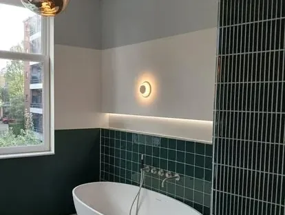 Maatwerk sanitair en tegelwerk in een gerenoveerde badkamer.