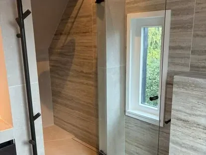 Maatwerk sanitair en tegelwerk in een gerenoveerde badkamer.