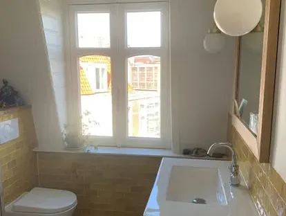 Maatwerk sanitair en tegelwerk in een gerenoveerde badkamer.