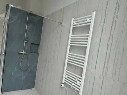 Badkamerrenovatie met zorgvuldig afgestemd sanitair, tegelwerk en verlichting.