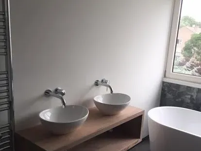 Maatwerk sanitair en tegelwerk in een gerenoveerde badkamer.