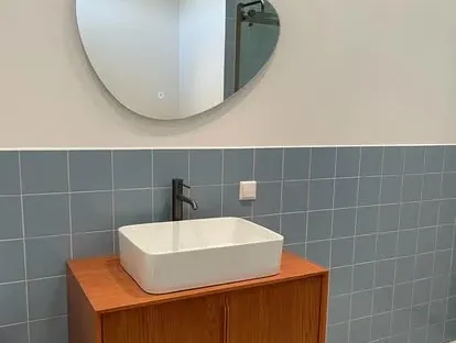 Badkamerrenovatie met zorgvuldig afgestemd sanitair, tegelwerk en verlichting.