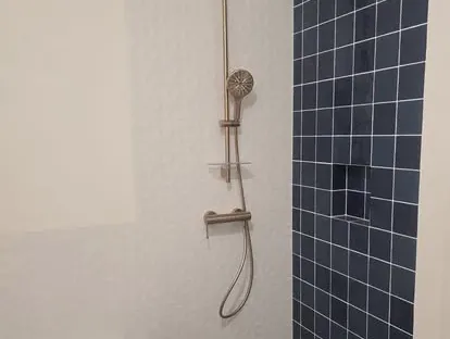 Badkamerrenovatie met zorgvuldig afgestemd sanitair, tegelwerk en verlichting.