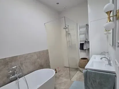 Badkamerrenovatie met zorgvuldig afgestemd sanitair, tegelwerk en verlichting.
