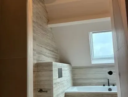 Badkamerrenovatie met zorgvuldig afgestemd sanitair, tegelwerk en verlichting.