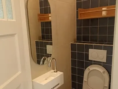 Badkamerrenovatie met zorgvuldig afgestemd sanitair, tegelwerk en verlichting.