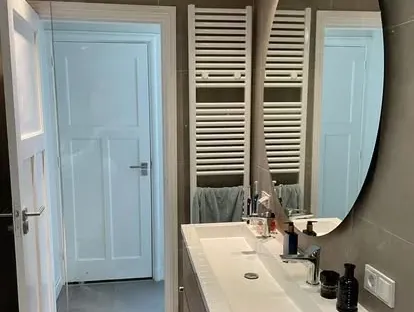 Badkamerrenovatie met zorgvuldig afgestemd sanitair, tegelwerk en verlichting.