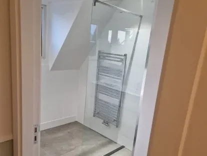 Badkamerrenovatie met zorgvuldig afgestemd sanitair, tegelwerk en verlichting.