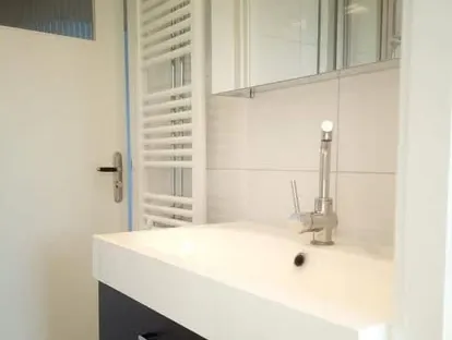 Maatwerk sanitair en tegelwerk in een gerenoveerde badkamer.