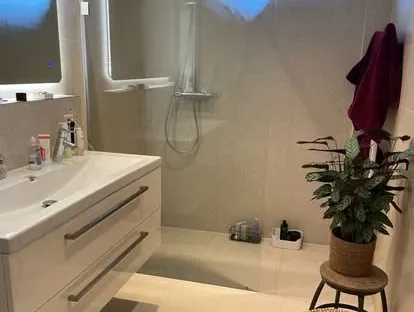 Maatwerk sanitair en tegelwerk in een gerenoveerde badkamer.