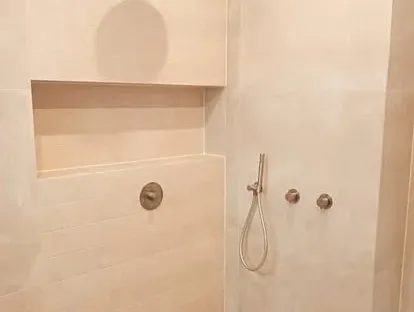 Maatwerk sanitair en tegelwerk in een gerenoveerde badkamer.