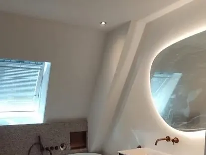 Badkamerrenovatie met zorgvuldig afgestemd sanitair, tegelwerk en verlichting.