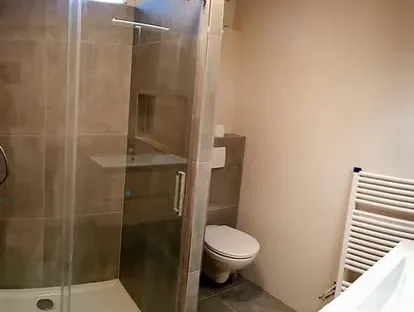 Badkamerrenovatie met zorgvuldig afgestemd sanitair, tegelwerk en verlichting.