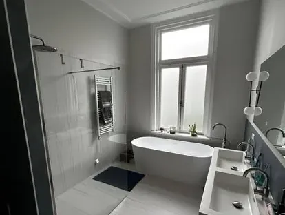 Maatwerk sanitair en tegelwerk in een gerenoveerde badkamer.